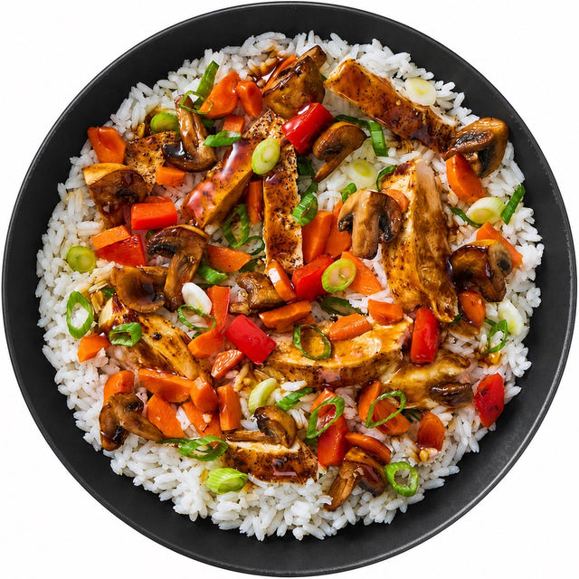 Teriyaki chicken stir-fry over rice in a matte black bowl