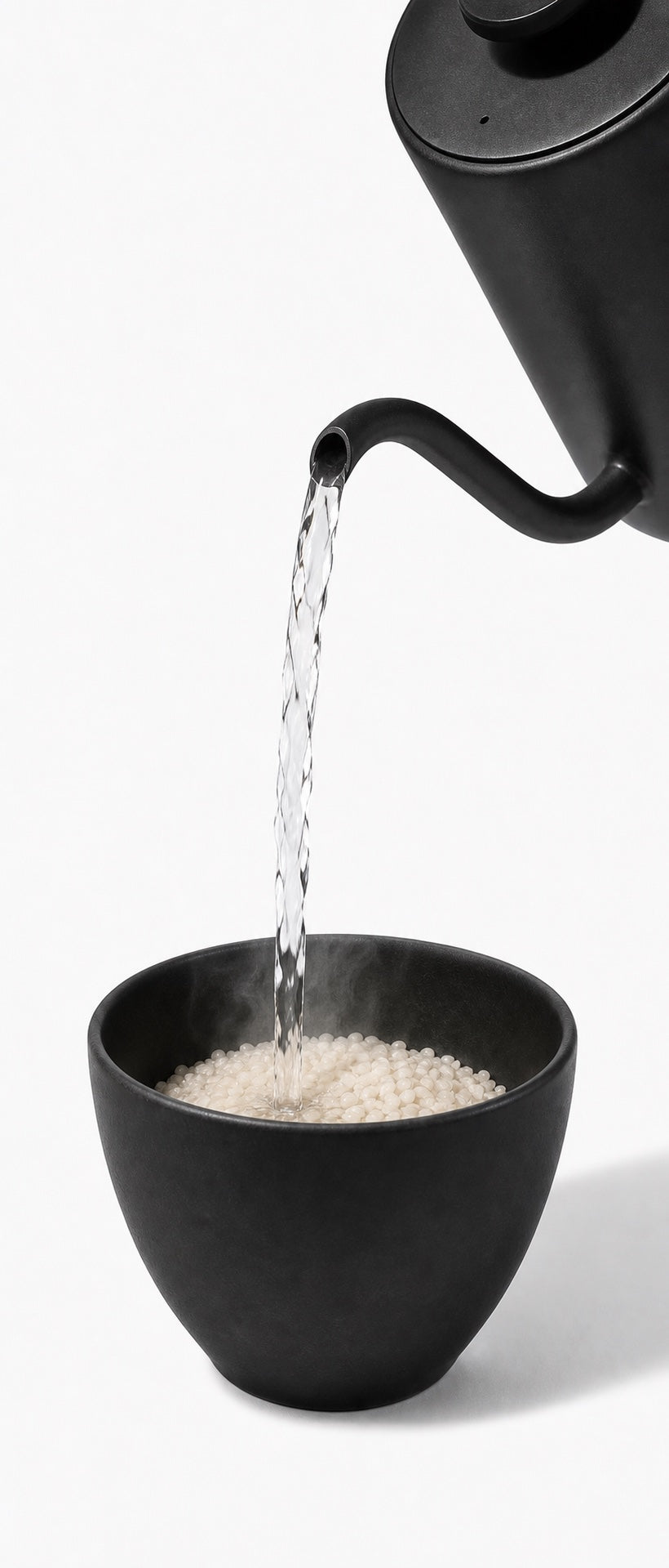 Boiling water pouring from a kettle into a bowl of CUT KITCHEN rice